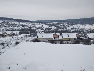 Paisaje de invierno con montañas y árboles, casas pueblo rural nieve en Rumanía Transilvania