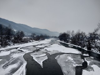 Río congelado con nieve e hielo en la temporada de invierno. Rumania, Transilvania, ciudad de Nasaud.Paisaje de invierno