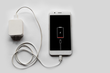 Smartphone Connected to charger for Fast Charge through USB Cable white color on white background