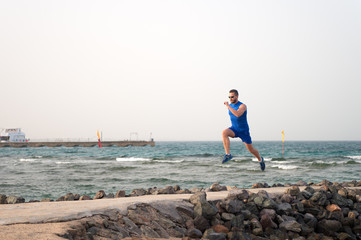 athlete runner along sea coast. running to success. summer vacation. copy space. speed concept....