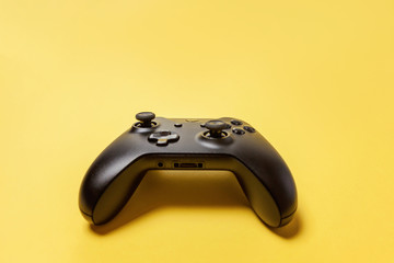 Black joystick gamepad, game console on yellow colourful trendy modern fashion pin-up background....
