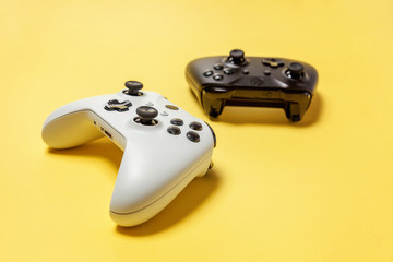 White and black two joystick gamepad, game console on yellow colourful trendy modern fashion pin-up...