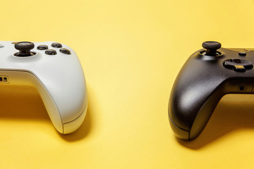 White and black two joystick gamepad, game console on yellow colourful trendy modern fashion pin-up...