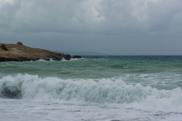 Fototapeta na wymiar Waves in a bay of the Aegean Sea in Rhodes.