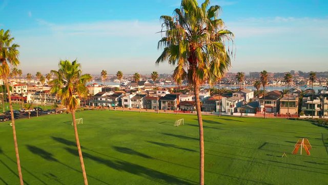 Aerial view Newport Beach peninsula, Orange County California coastal real estate and neighborhood indicative American wealth with palm trees on sunny day.