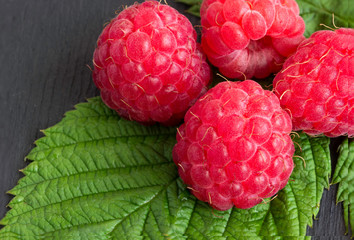 Ripe raspberries on a wooden background.