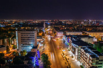 Aerial view of night city Voronezh downtown with illuminated buildings, malls, roads with car traffic, drone photo