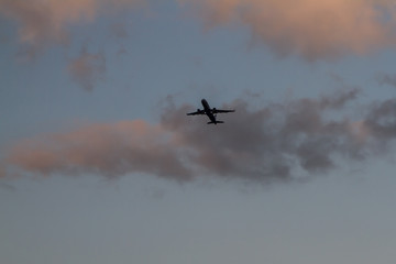 Passenger aircraft. Airplane in the sky, takes off against the blue sky and sunset clouds