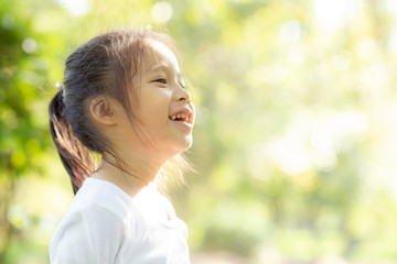 Portrait face of cute asian little girl and child happiness and fun in the park in the summer,...