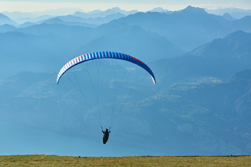 Paraglider flying over the Garda Lake,Panorama of the gorgeous Garda lake surrounded by mountains, Malcesine,Italy