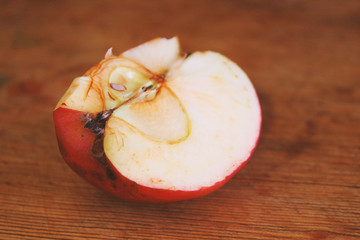 Red sliced apple on a wooden board. Close-up. Background.