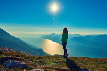 A beautiful woman admiring the beautiful Lake Garda on  Monte Baldo, Panorama of the gorgeous Garda...