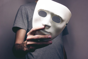 man holds mask in his hand