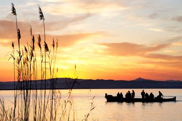 Silueta de un grupo de personas paseando en barca por la Albufera de Valencia © korgan75