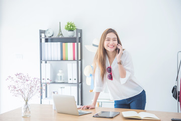 Portrait beautiful asian designer woman working with computer in tailer fabric fashion small business shop. SME business concept