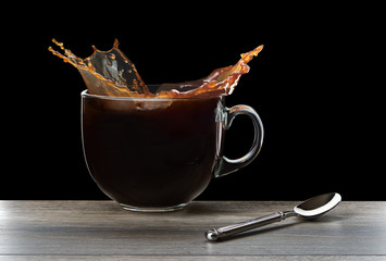 Splash of black coffee in cup