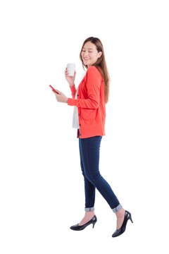 Full length of beautiful asian woman holding smart phone and coffee cup isolated over white background