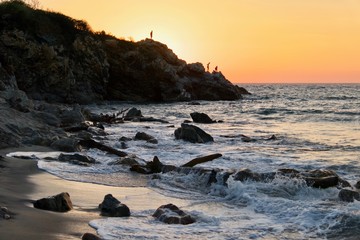 Couché de soleil avec des pêcheurs sur une falaise, Puerto Escondido, Oaxaca, Mexique.
