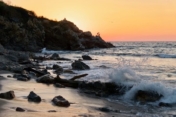 Couché de soleil avec des pêcheurs sur une falaise, Puerto Escondido, Oaxaca, Mexique.