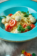 Children's pasta with meatballs and basil among children's toys 