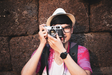 Young Man Photographer Traveler with backpack taking photo with his camera, Great wall in background at historical place. Lifestyle and travel concept.