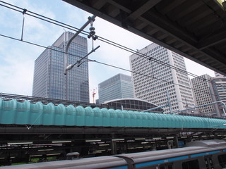 Obraz premium View from the railway platform of Tokyo Train Station with modern office towers under blue sky