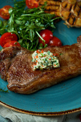Steak with vegetables and salad, with roasted garlic