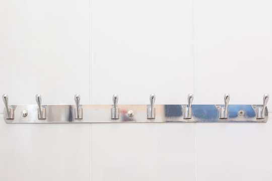 Bathroom hook mounted at the wall in the bathroom. Hooks for clothes and towels in the bath. Metal hooks for towels.