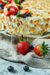 Strawberry meringue cake with almond petals, on newspaper 