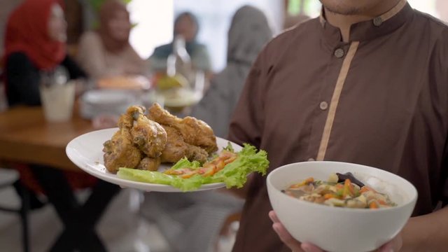 muslim male with food for dinner with friends together