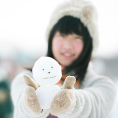 雪だるまを持ち微笑む中学生