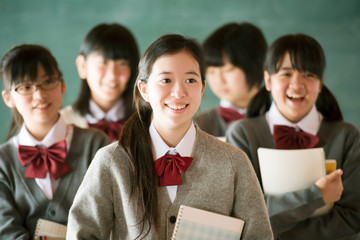 黒板の前で微笑む中学生