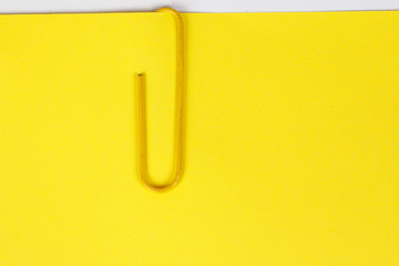 Paper clip holding on blank colour paper text copy space note