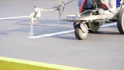 Man striping parking lot with a machine
