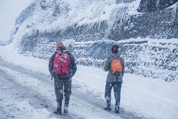 Fototapeta na wymiar Two guys walking at heavy snowy day in the manali. Adventure, Snowfall winter concept - Image