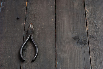 old pliers on black wooden