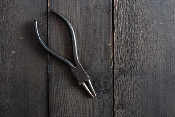 old pliers on black wooden