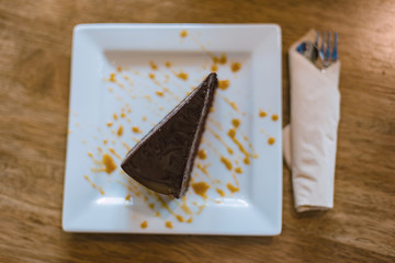 Chocolate brownie on the white plate and wooden table, top view
