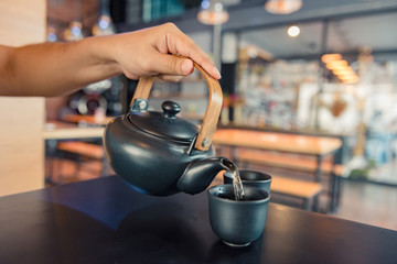 Kettle pouring boiling water into a cup during coffee time in coffee shop - Powered by Adobe