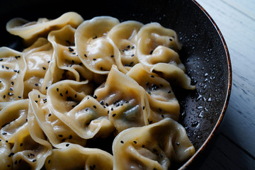 A plate of fried dumplings sprinkled with sesame