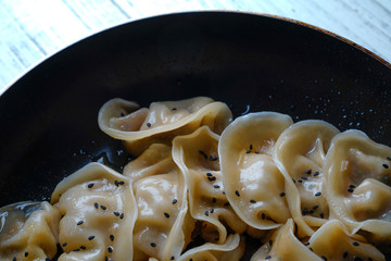 A plate of fried dumplings sprinkled with sesame