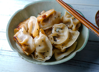 A plate of fried dumplings sprinkled with sesame