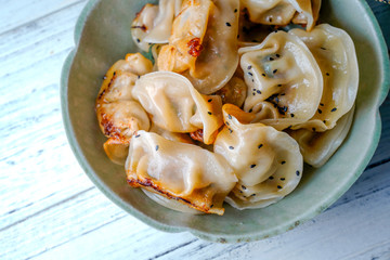 A plate of fried dumplings sprinkled with sesame