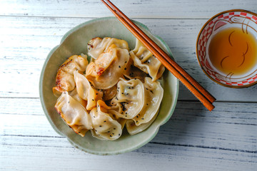 A plate of fried dumplings sprinkled with sesame