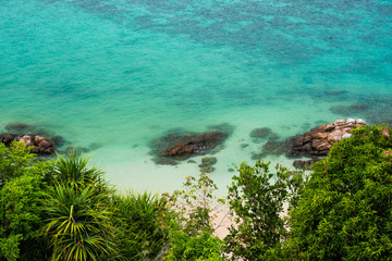 Coral reefs along the coast Turquoise water with green bushes in front of the sea, waves make the surface clear as emeralds For the background