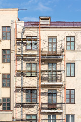 renovation of old residential building with construction scaffolding near wall