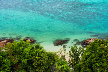 Fototapeta na wymiar Coral reefs along the coast Turquoise water with green bushes in front of the sea, waves make the surface clear as emeralds For the background