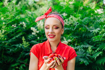 Beautiful young pin up girl with bright make up and fresh natural strawberry.