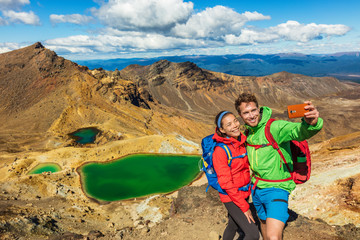 New Zealand Tongariro Alpine Crossing Hiking tourists couple selfie at Emerald Lakes. Happy...