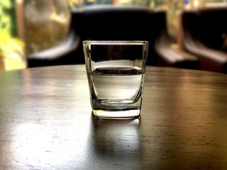 Glass of water on brown wooden table in the cafe